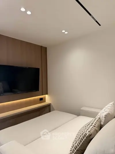 Modern living room with sleek TV setup and cozy sofa, perfect for relaxation.