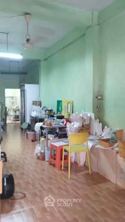 Spacious interior with wooden flooring and vibrant green walls, ideal for creative workspace or storage.