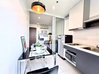 Modern kitchen with sleek appliances and dining area in stylish apartment