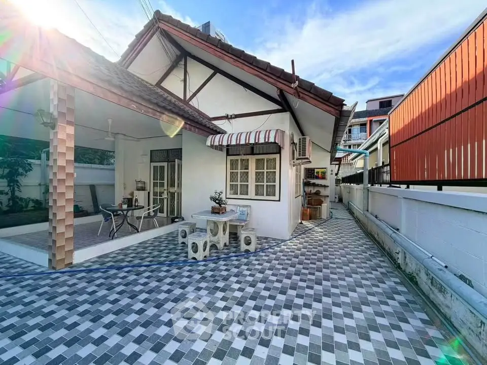 Charming single-story home with spacious tiled patio and covered outdoor seating area.