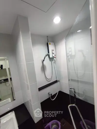 Modern bathroom with sleek shower and contemporary fixtures in a stylish real estate property.