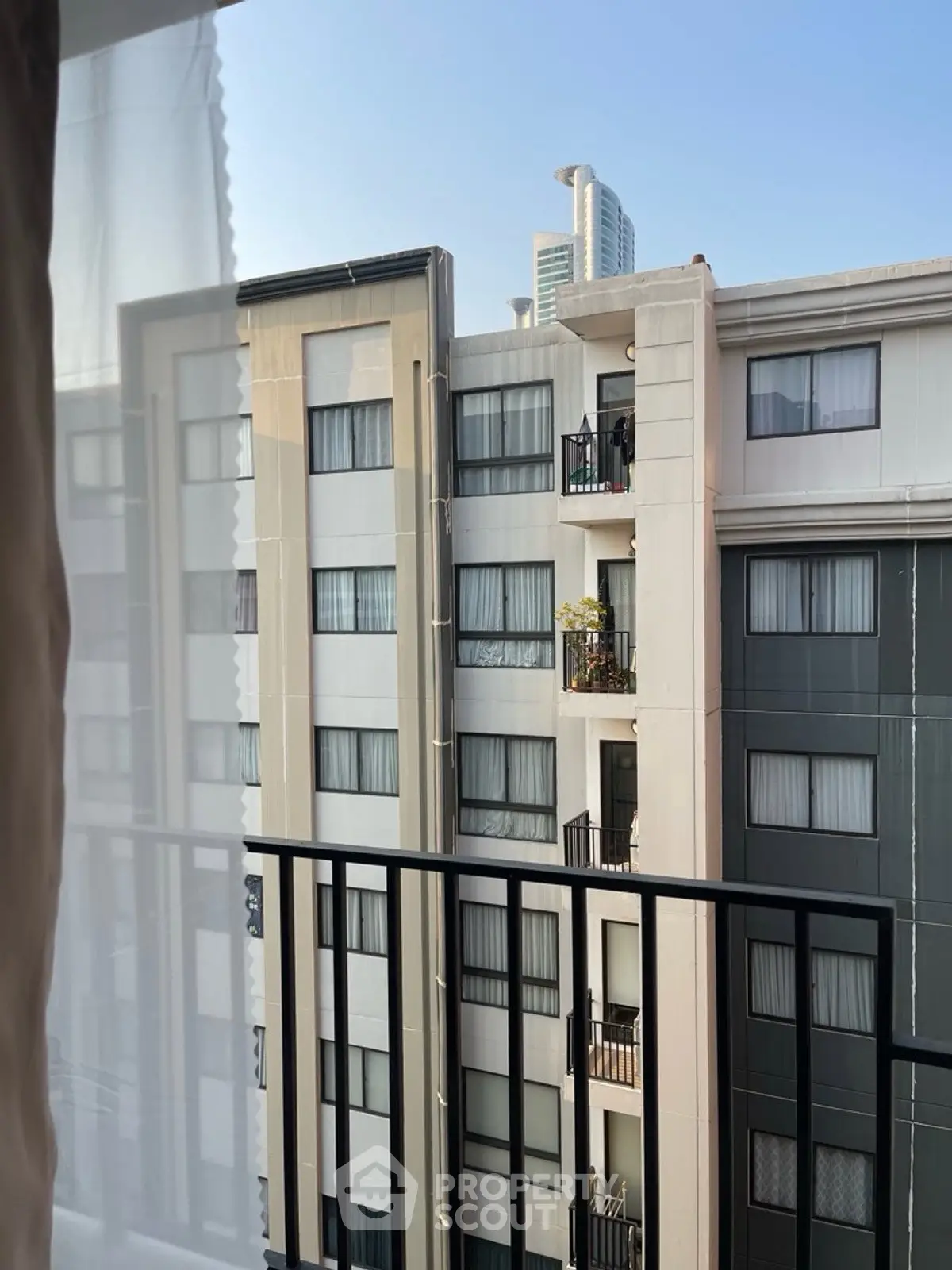 Modern apartment building view from balcony with cityscape backdrop