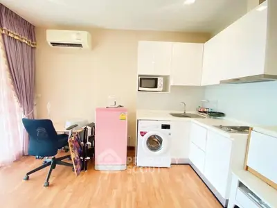 Modern kitchen with washing machine and pink fridge in cozy apartment
