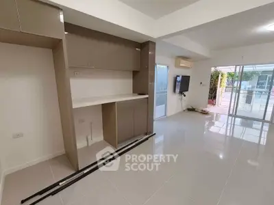 Spacious modern living room with sleek tile flooring and large windows for natural light.