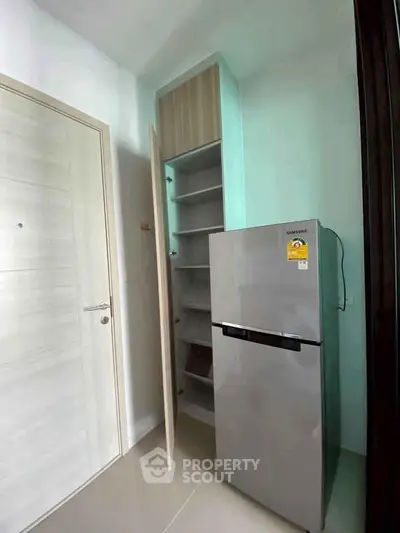 Modern kitchen corner with sleek fridge and built-in storage shelves