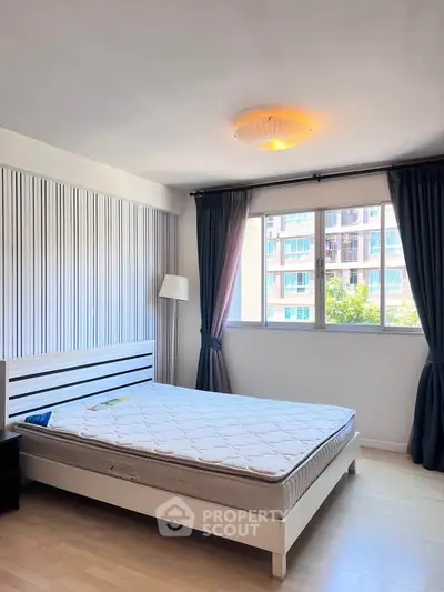 Bright bedroom with large window and modern decor in a stylish apartment.