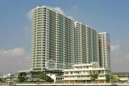 Modern high-rise residential building with clear blue sky backdrop.