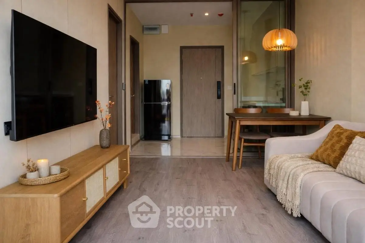 Modern living room with stylish decor, flat-screen TV, and cozy seating area.