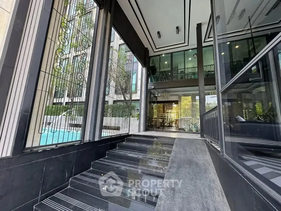 Elegant building entrance with modern glass facade and stylish staircase