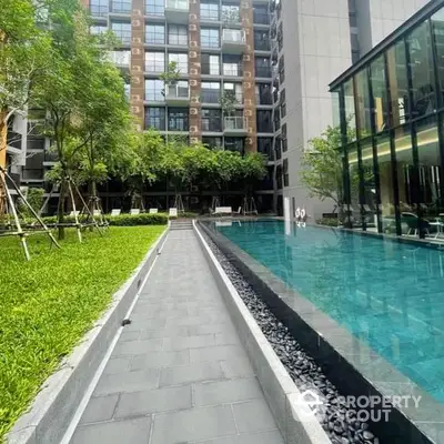 Luxurious urban oasis with a pristine pool surrounded by lush greenery and modern architecture, offering a serene escape in the heart of the city.