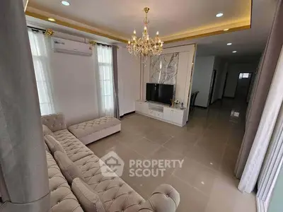 Luxurious living room with elegant chandelier and plush seating, perfect for relaxation and entertainment.