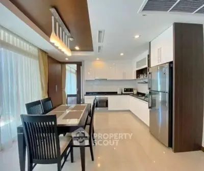 Modern kitchen with dining area, sleek cabinetry, and stainless steel appliances.