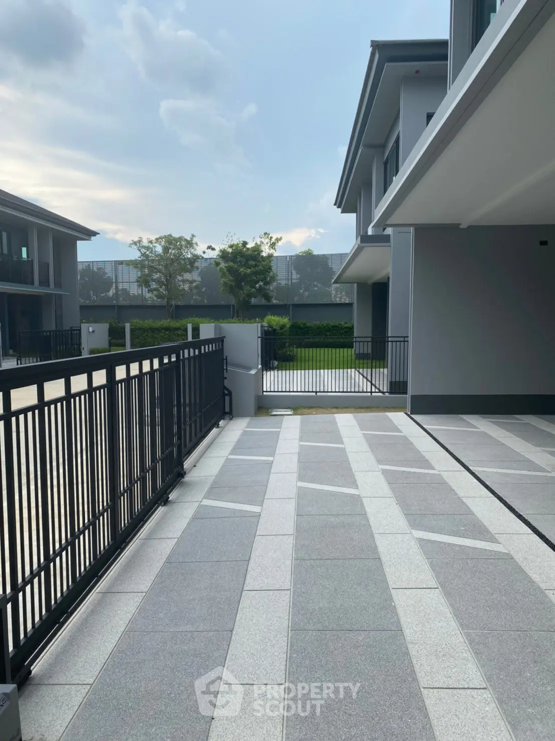 Modern residential building with spacious driveway and sleek design.