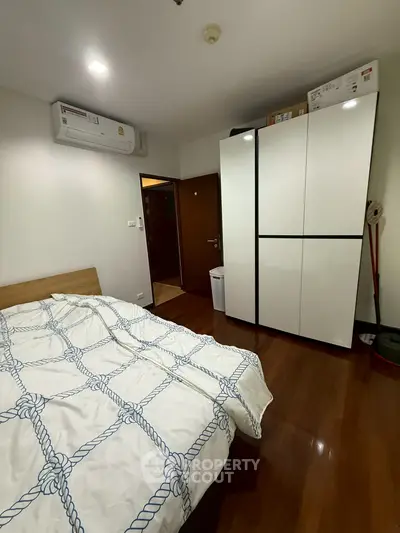 Cozy bedroom with modern wardrobe and air conditioning, perfect for comfortable living.