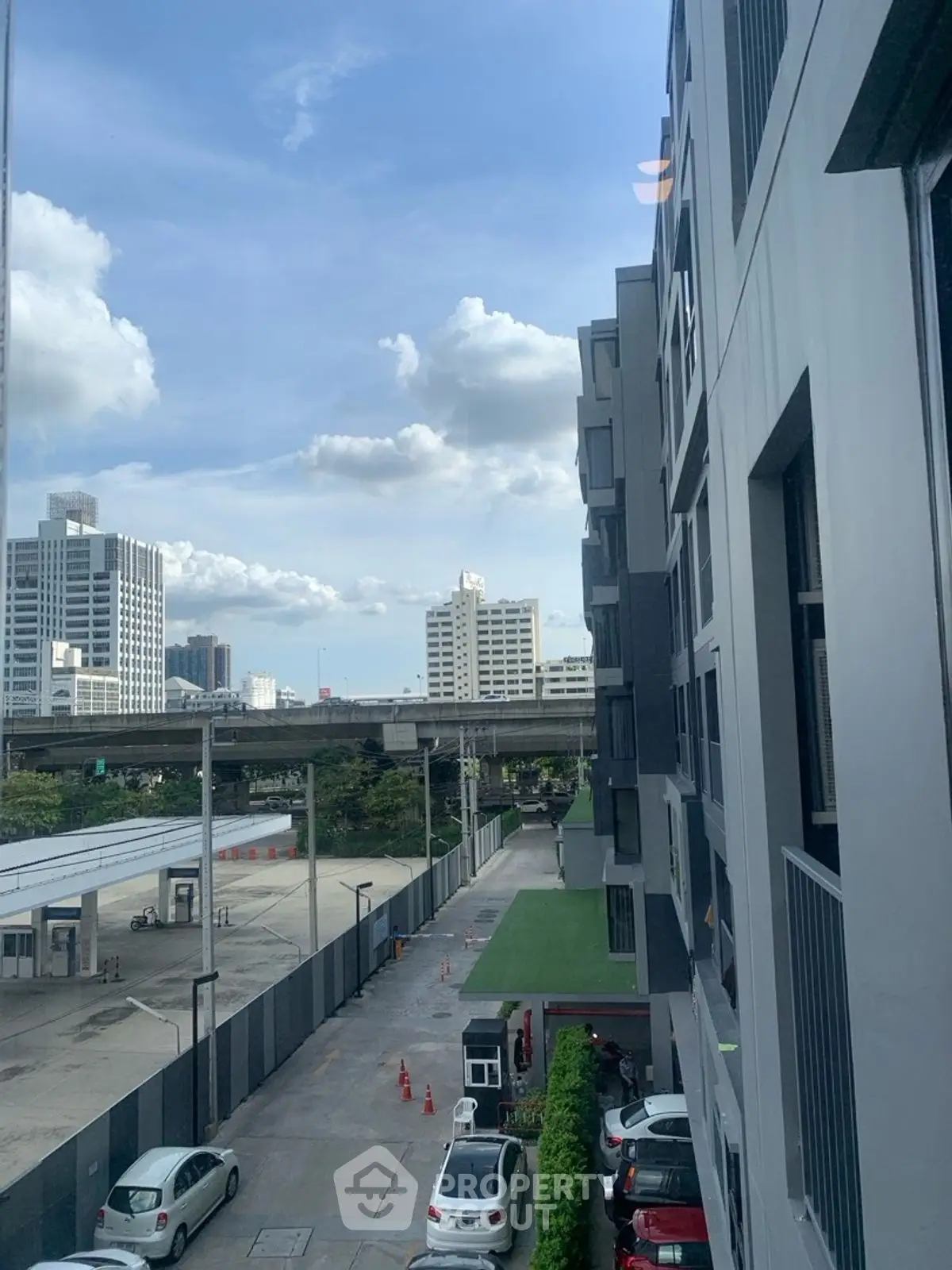 Urban apartment view with city skyline and parking area