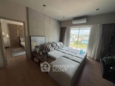 Spacious modern living room with large windows and stylish decor, offering a cozy and inviting atmosphere.