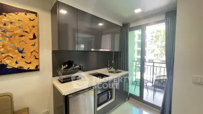 Modern kitchen with sleek cabinetry and balcony view in a stylish apartment