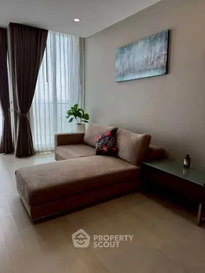 Modern living room with stylish sofa and floor-to-ceiling windows in a cozy apartment.