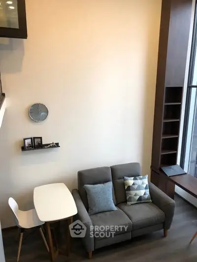 Modern living room with cozy sofa, stylish decor, and large window for natural light.