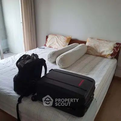 Cozy bedroom with double bed and luggage, ideal for travelers.