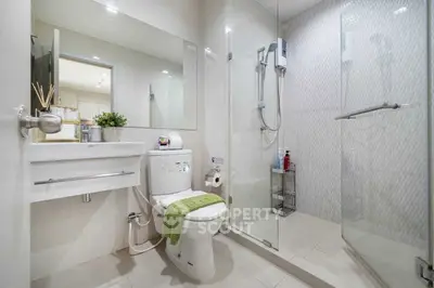 Modern bathroom with glass shower and sleek fixtures in a contemporary home.