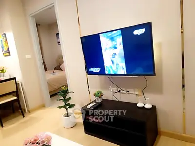 Modern living room with wall-mounted TV and view into cozy bedroom