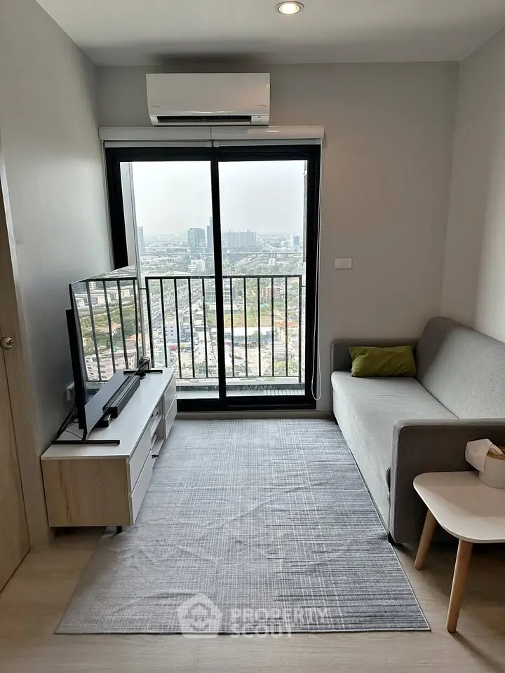 Modern living room with city view, featuring a cozy sofa and sleek TV setup.