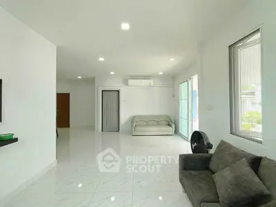 Spacious modern living room with sleek white tiles and comfortable seating