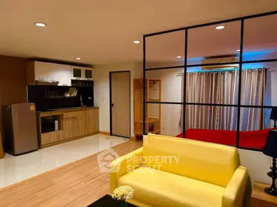 Modern open-plan living room with vibrant yellow sofa and sleek kitchen area.