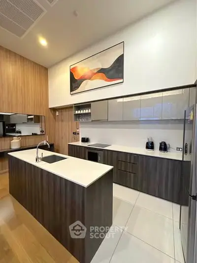 Modern kitchen with sleek cabinetry and island, featuring built-in appliances and stylish decor.