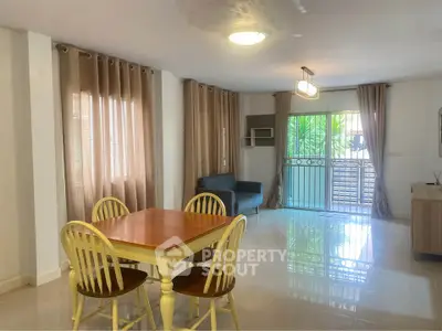 Spacious living room with dining area and large windows in modern apartment.
