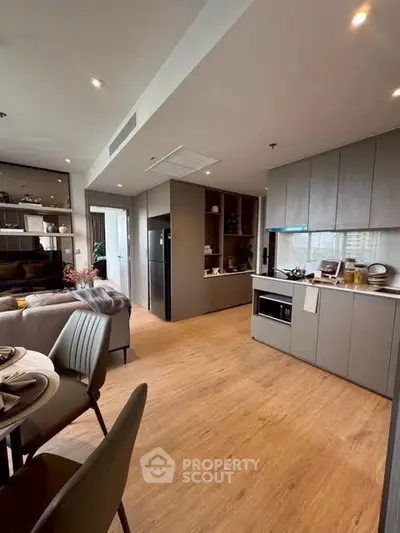 Modern open-plan kitchen and living area with sleek design and wooden flooring.