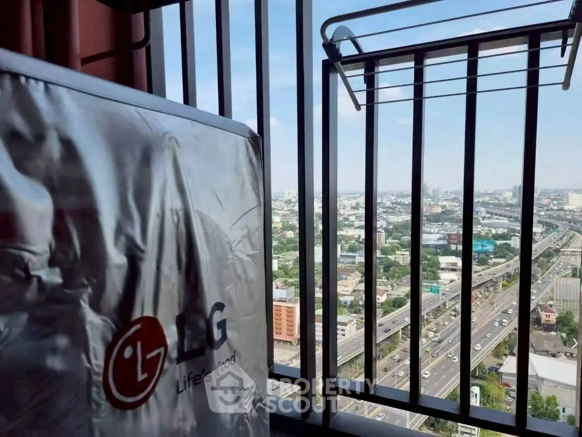 Stunning high-rise balcony view with cityscape and highway, featuring a modern LG appliance.