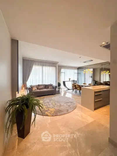 Luxurious open-plan living room with elegant decor and modern kitchen in a stylish apartment.