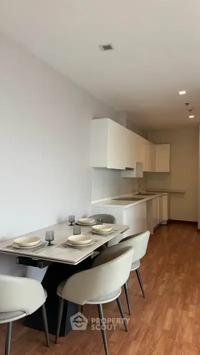 Modern kitchen with sleek white cabinets and dining area in open layout