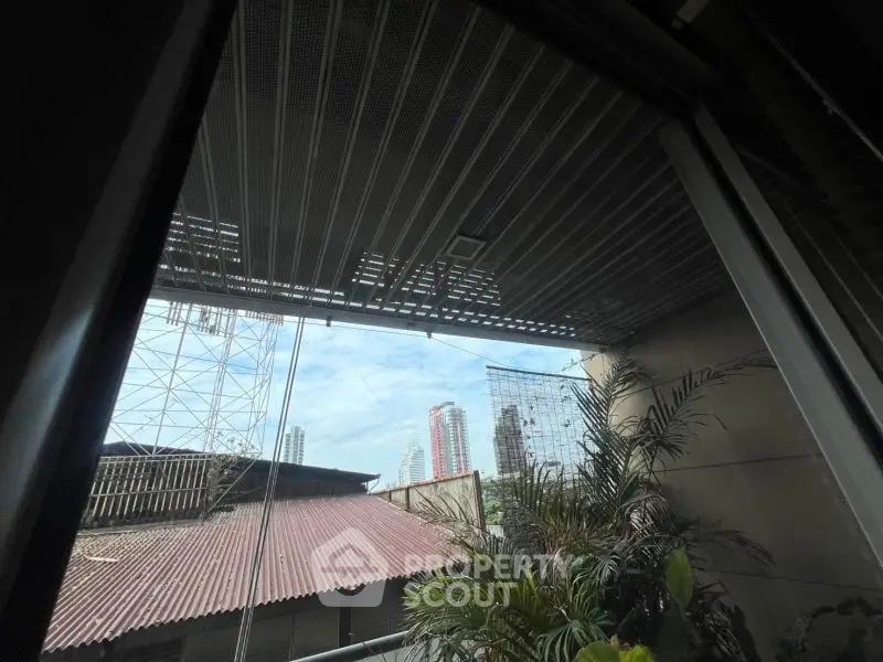 Urban balcony view with city skyline and greenery, ideal for modern living.