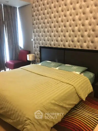 Luxurious bedroom with stylish decor and plush bedding in modern apartment.