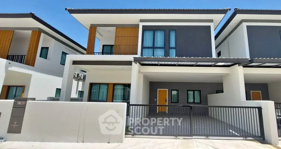 Modern two-story house with sleek design and spacious driveway in a sunny neighborhood.