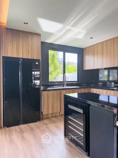 Modern kitchen with sleek black appliances and wooden cabinetry