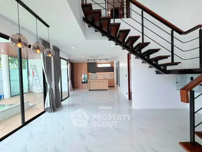 Spacious modern living room with open kitchen and stylish staircase in luxury home