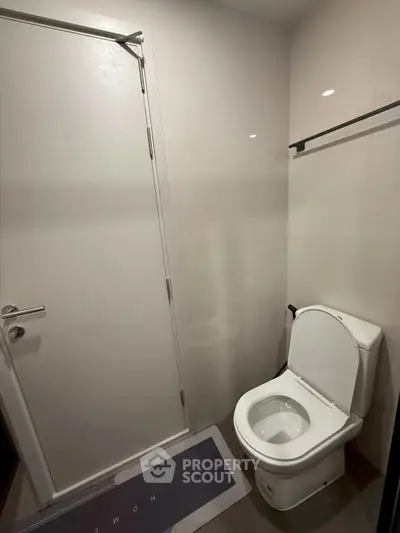 Modern bathroom with sleek white toilet and minimalist design.