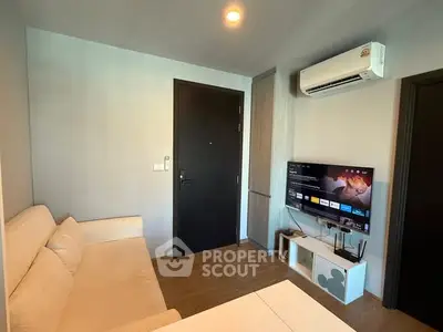 Modern living room with air conditioning and wall-mounted TV, featuring a cozy sofa and wooden flooring.