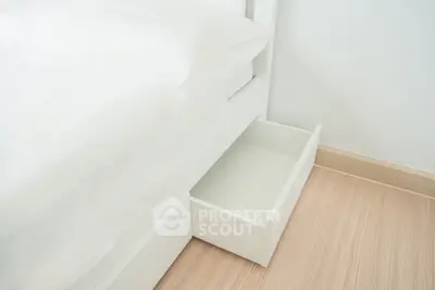 Modern bedroom with sleek under-bed storage drawer and minimalist design.