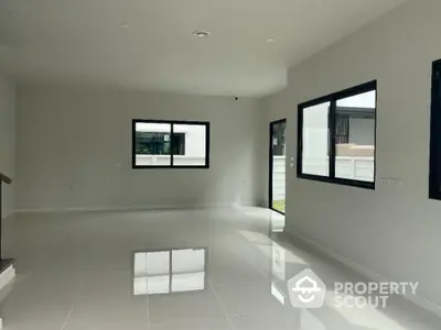 Spacious modern living room with large windows and glossy tiled floor