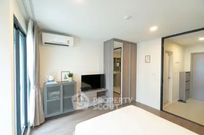 Modern bedroom with sleek design, featuring built-in wardrobe and air conditioning, perfect for urban living.