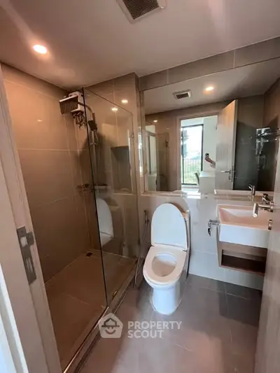 Modern bathroom with glass shower and sleek fixtures in a contemporary apartment.