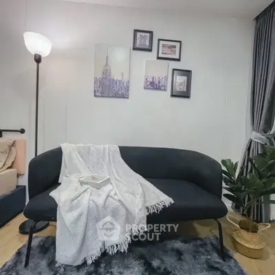 Stylish living room with modern black sofa, cozy decor, and elegant wall art for a chic urban vibe.