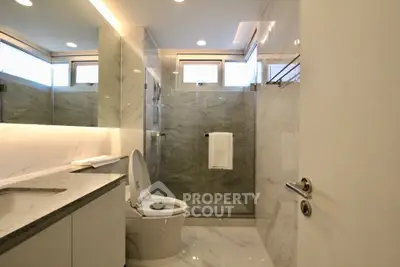 Luxurious modern bathroom with marble finishes and glass shower enclosure