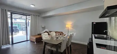 Modern living room with open layout, stylish furniture, and natural light from large windows.