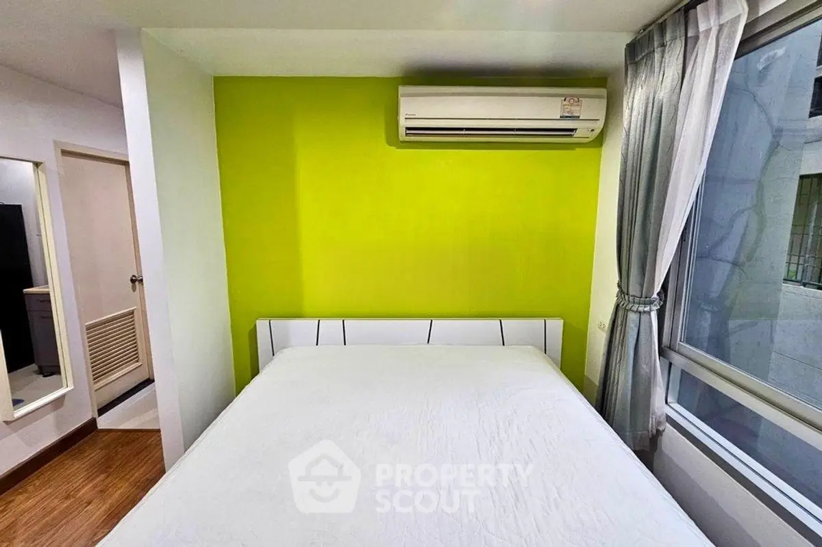 Modern bedroom with vibrant green accent wall and large window